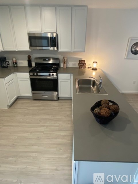 A kitchen with white cabinets and a stainless steel oven.