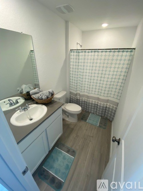 A bathroom with a toilet, sink, and shower.