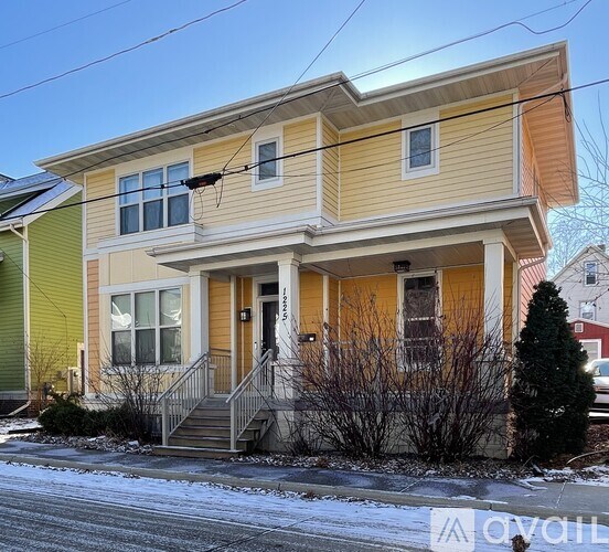 A two-story house with a yellow and green exterior.