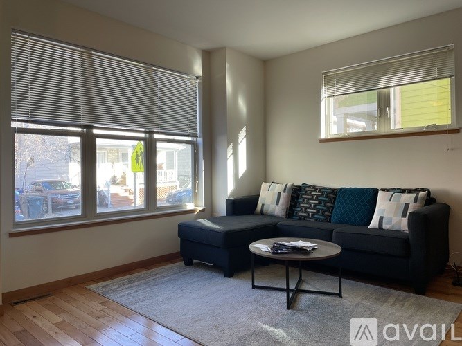 A living room with a black couch and a coffee table.