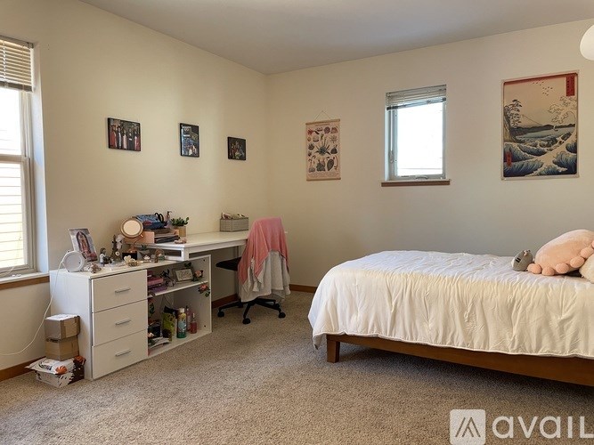A bedroom with a bed, desk, and chair.