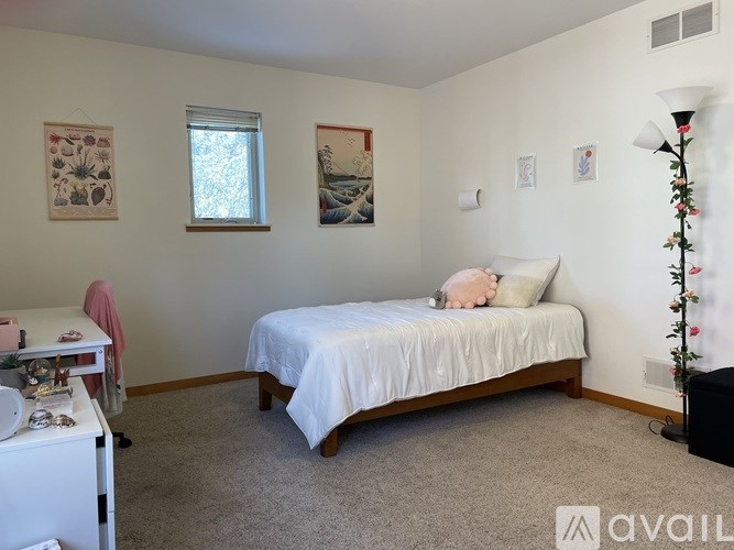 A bedroom with a bed, a dresser, and a window.