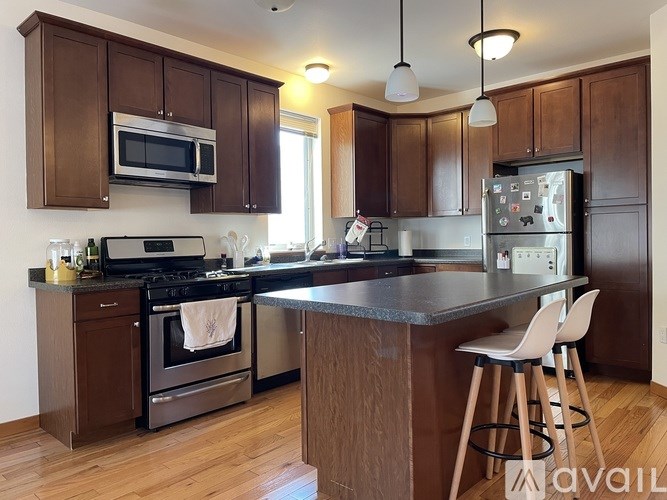 A kitchen with brown cabinets and a black stove top oven.