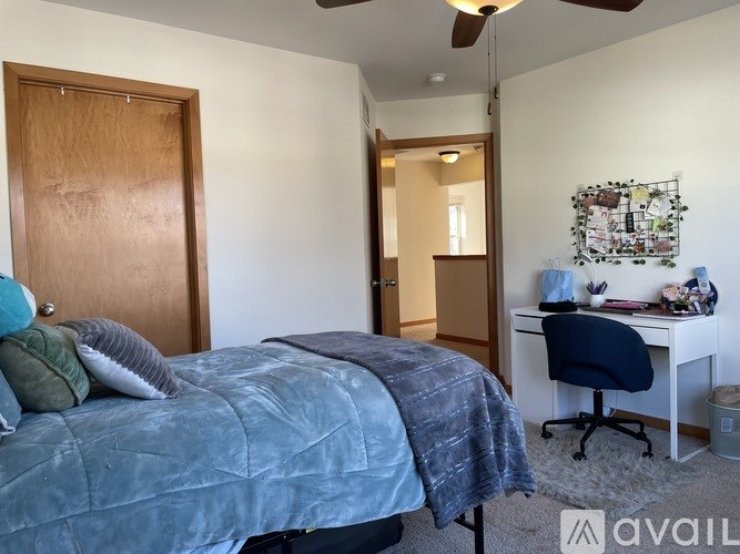 A bedroom with a bed, desk, and chair.