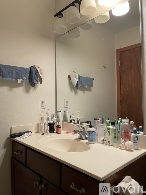 A bathroom with a sink, mirror, and towel rack.