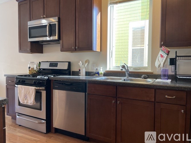 A kitchen with dark wood cabinets and stainless steel appliances.