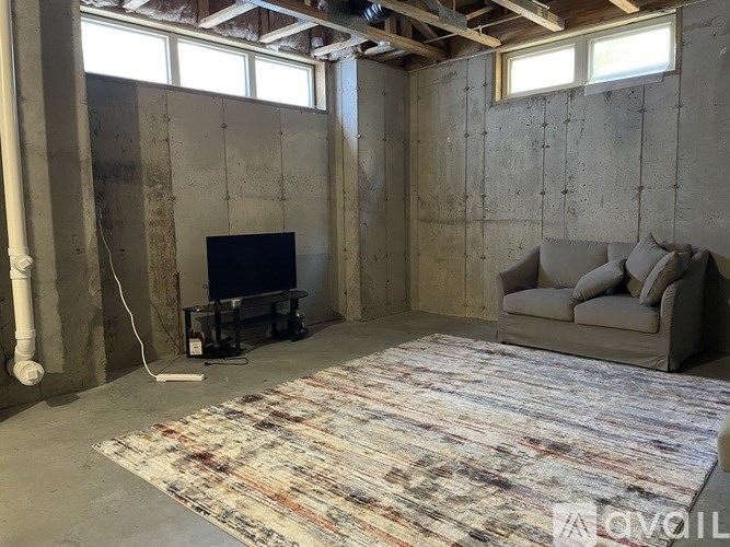 A living room under construction with a couch, television, and a rug.