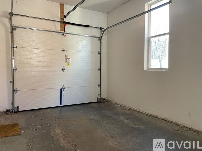 A garage with a white door and a window on the right side.