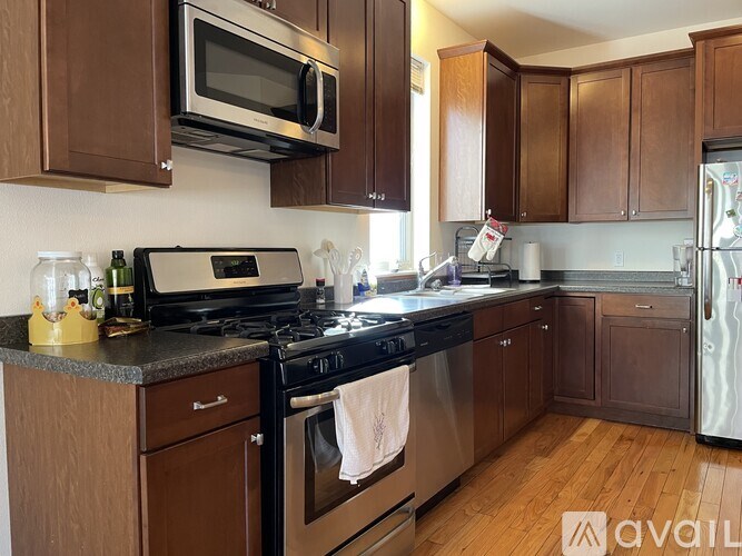 A kitchen with brown cabinets and a black stove top.