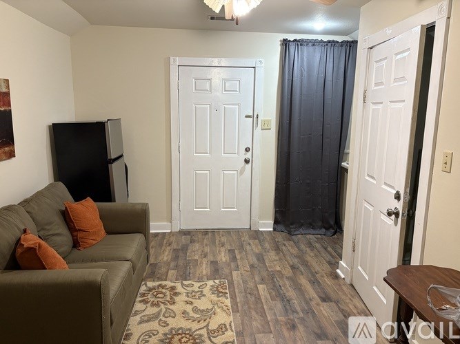 A living room with a couch, a television, and a rug.