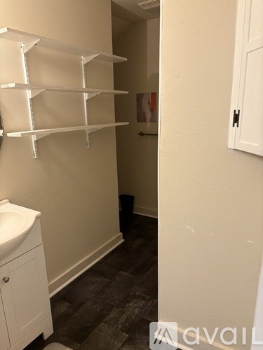A bathroom with a shower curtain and pictures on the wall.