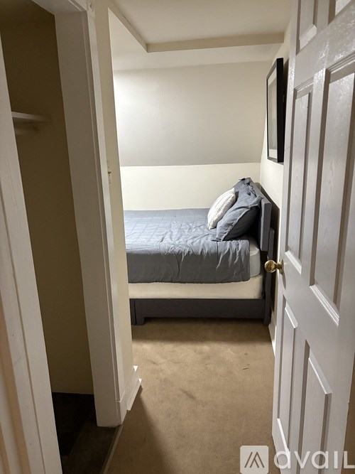 A shower with a marble wall and a white door.