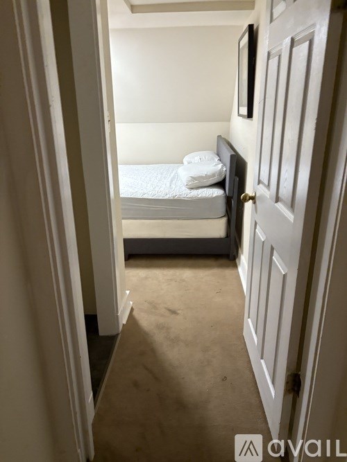 A small bedroom with a bed and a door.