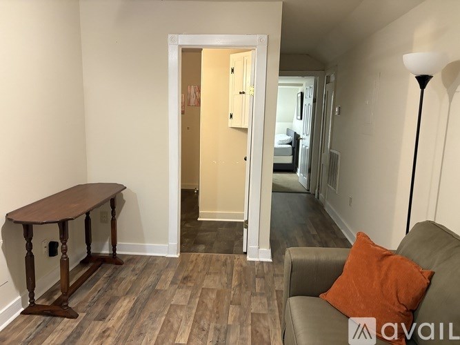 A room with a brown table and a grey couch.