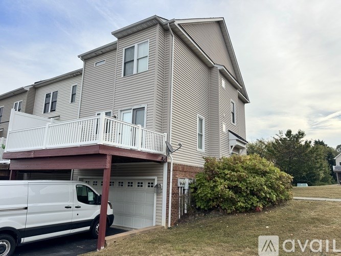 A two-story house with a white van parked in front.