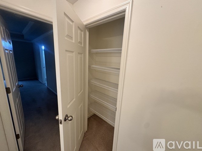 A white door with a handle and a small window in the hallway.