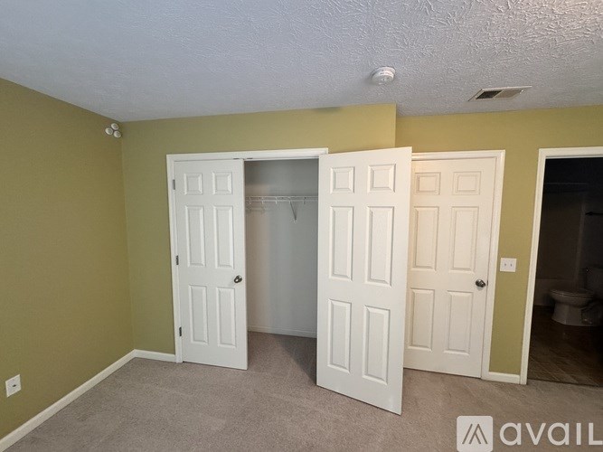 A room with two white doors open and one closed.