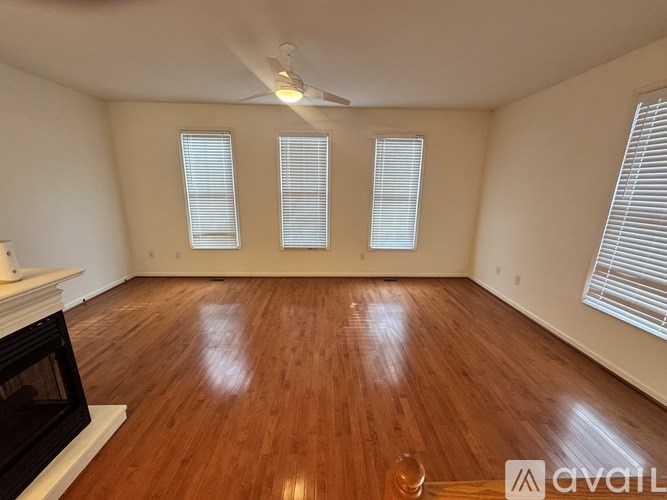 A room with wooden flooring and a fireplace.