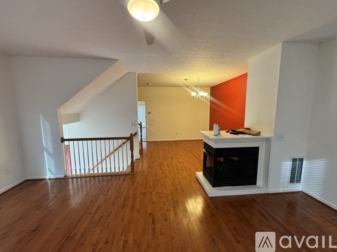 A living room with a fireplace and a staircase.
