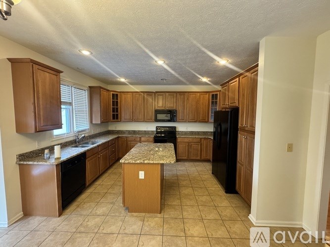 A kitchen with wooden cabinets and black appliances.