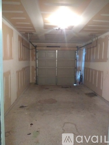 A garage with a closed door and a light on the ceiling.