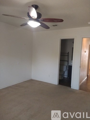 A room with a ceiling fan and a carpeted floor.