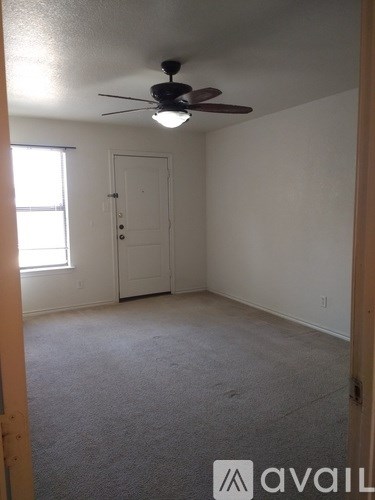 A room with a ceiling fan and a door.