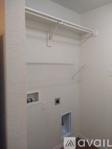 A white wall with a small window and a shelf.