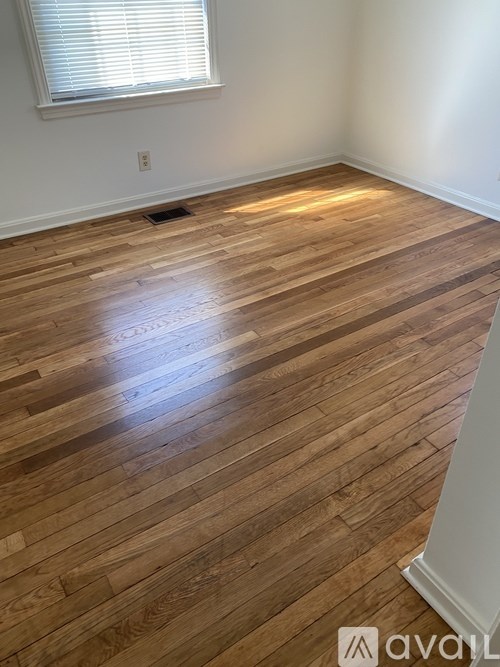 A room with wooden flooring and a window.