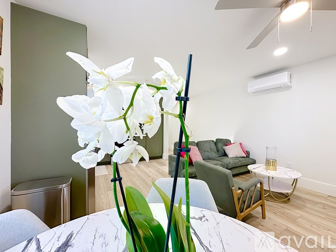 A white orchid plant is in a vase on a table.