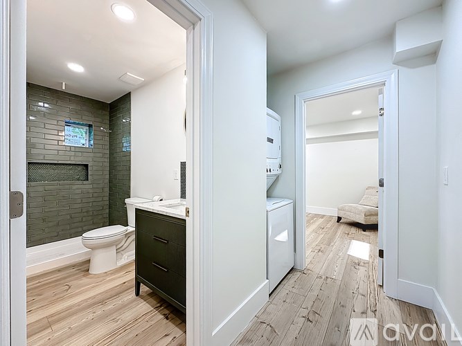 A bathroom with a toilet, sink, and a mirror.