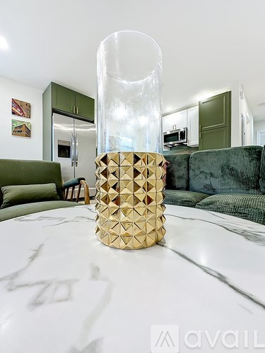 A table with a gold geometric vase on it.