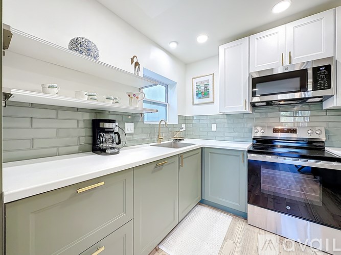 A kitchen with a black oven and white cabinets.