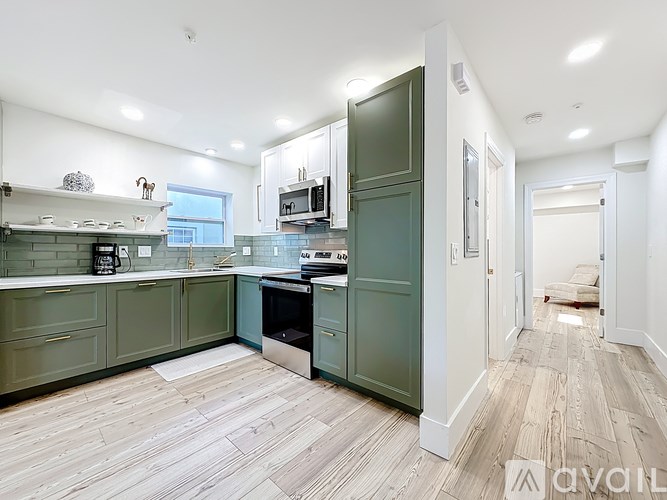 A kitchen with green cabinets and a white counter top.