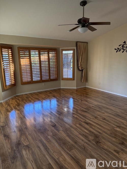 A room with wooden flooring and a ceiling fan.