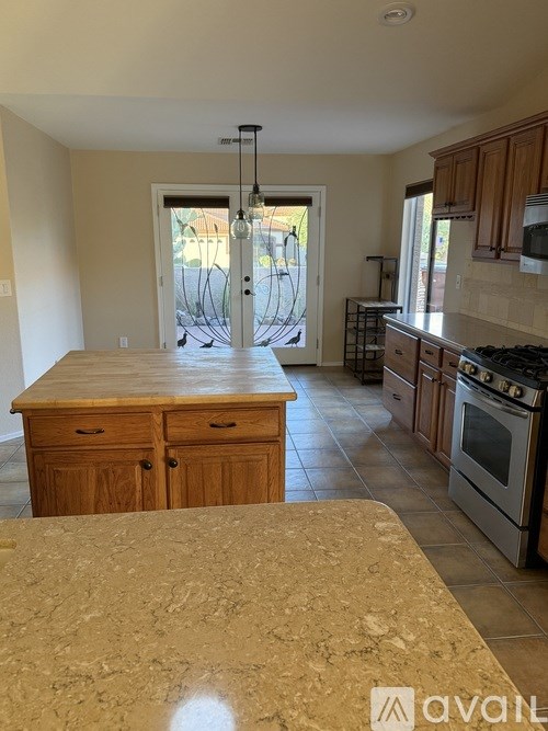 A kitchen with wooden cabinets and a marble countertop.