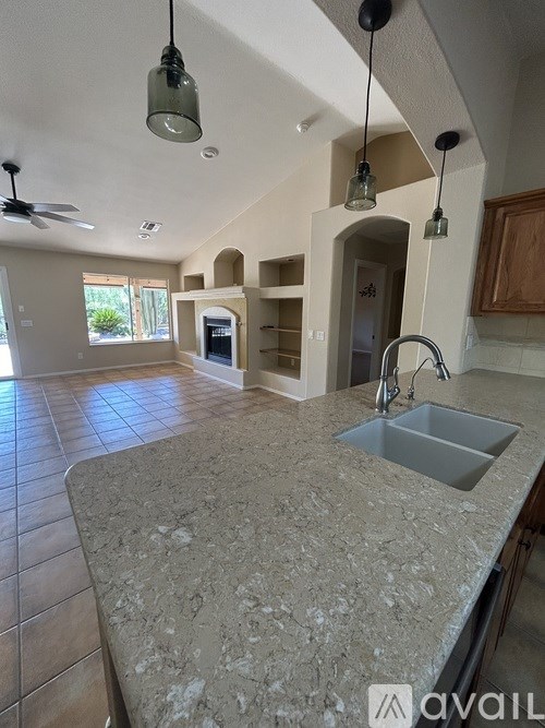 A kitchen with a granite countertop and a fan on the ceiling.