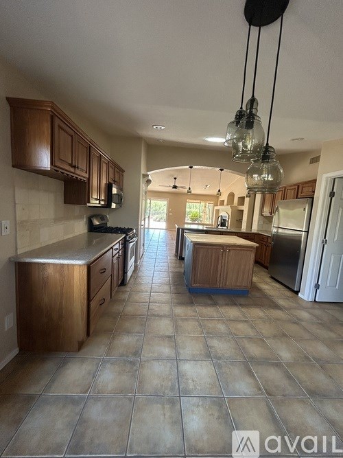 A kitchen with brown cabinets and a tiled floor.