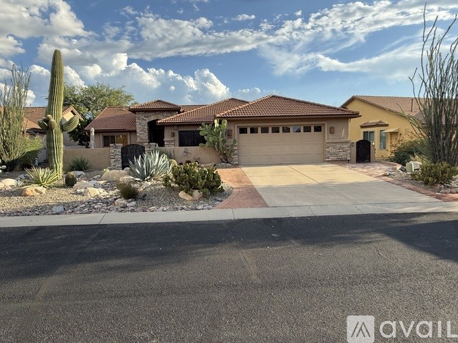 A house with a driveway and a cactus in front.