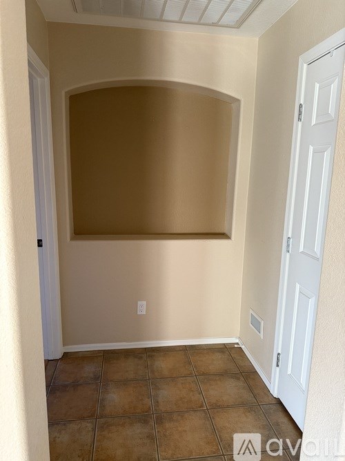 A room with a white door and a tiled floor.