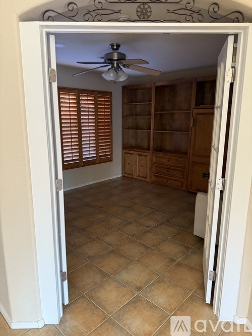 A room with a ceiling fan and tiled floor.