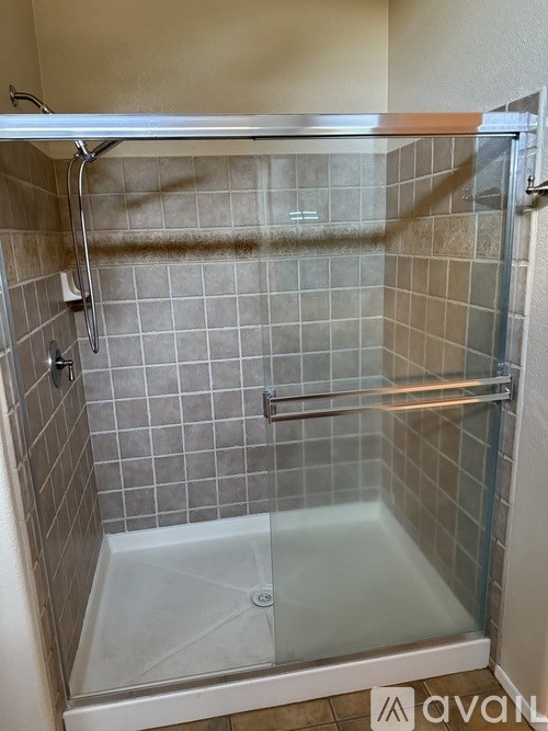 A shower stall with a glass door and tiled walls.