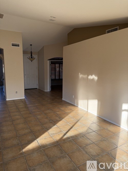A room with tiled flooring and a chandelier.