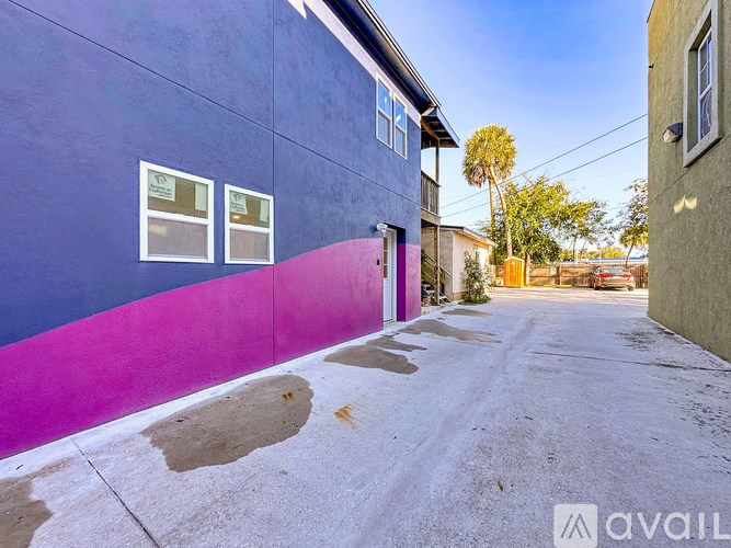 A purple and pink building with a sign that says "AVAIL" on it.