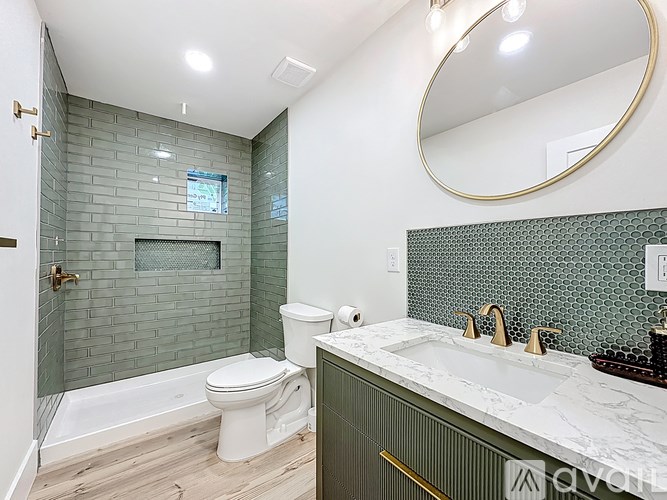 A bathroom with a toilet, sink, and a glass shower stall.
