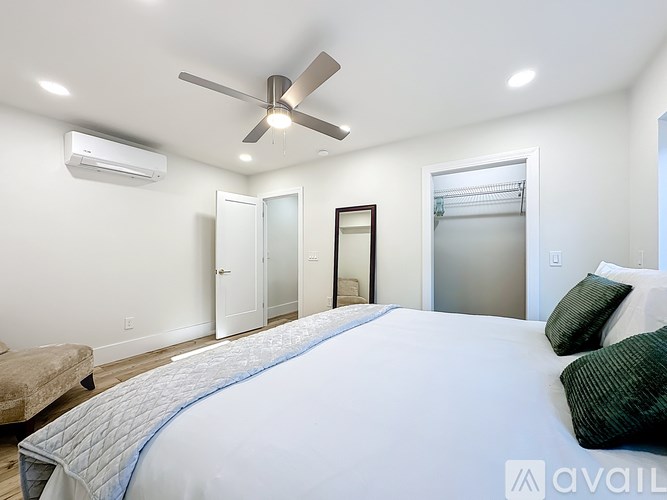 A bedroom with a large bed and a ceiling fan.