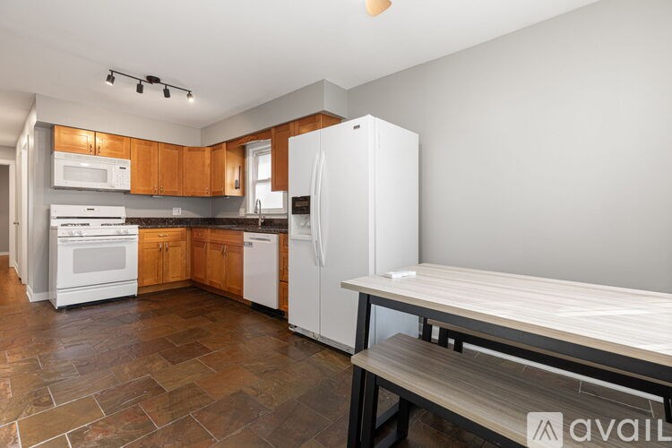 A kitchen with a white refrigerator, white oven, and wooden cabinets.