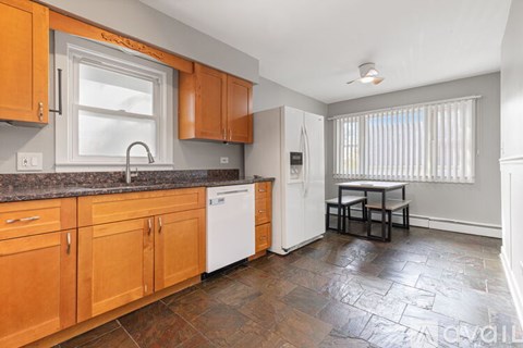 A kitchen with wooden cabinets and a white dishwasher.