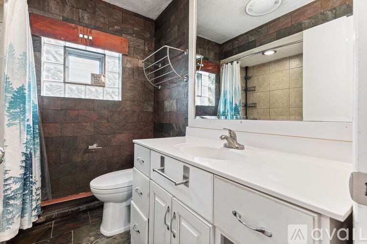 A bathroom with a toilet, sink, and shower.