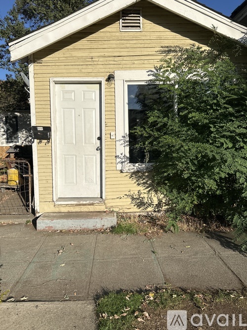 A small yellow house with a white door and a window.